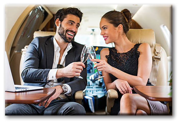 A man and woman enjoying a champagne toast aboard a Corporate Wings private chartered flight.