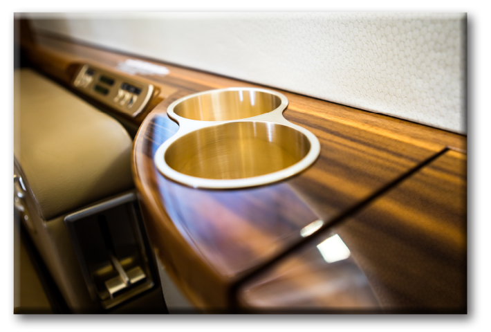 Close-up photograph of a cup holder and passenger controls inside the luxury interior of a private aircraft Gulfstream 450.
