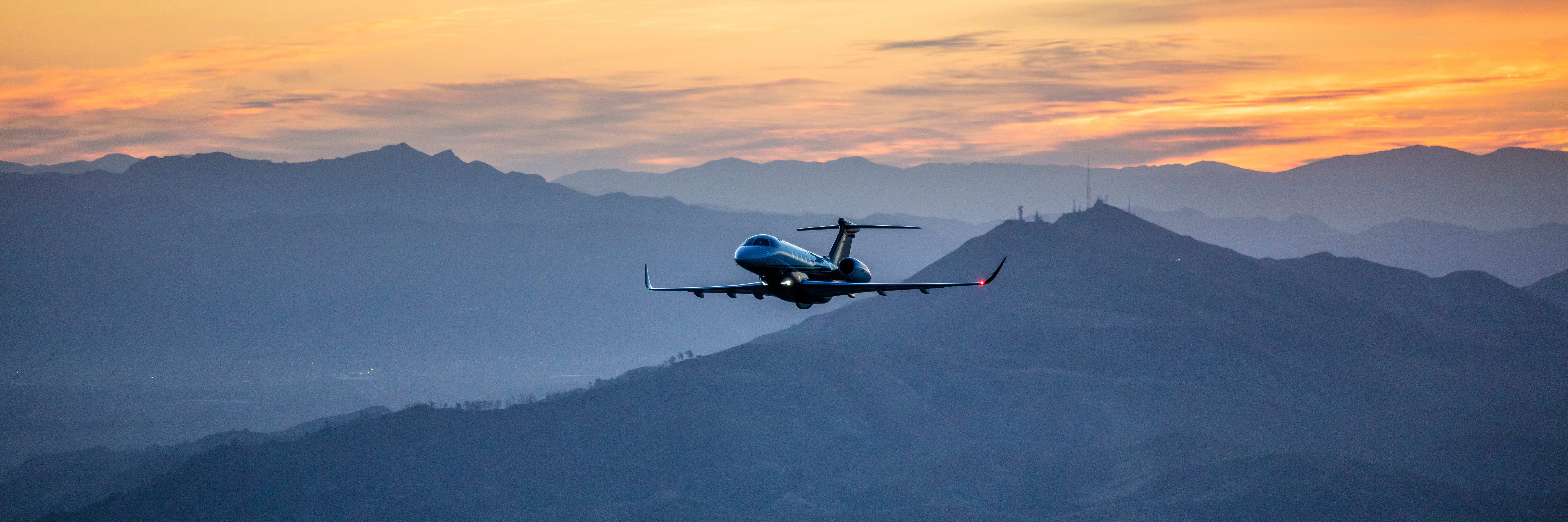 Golden sunset as a P600 flies over rocky landscape.